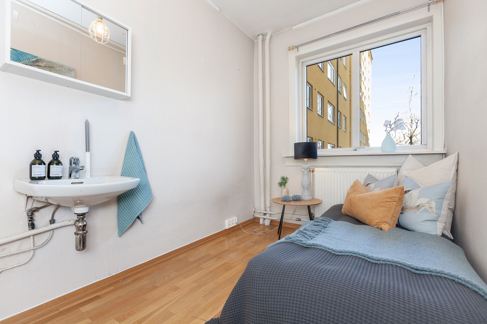 Lyst og pent soverom med parkettgulv, malte vegger og servant. Rommet vender ut mot bakgård/inngangspartiet. Galleribilde