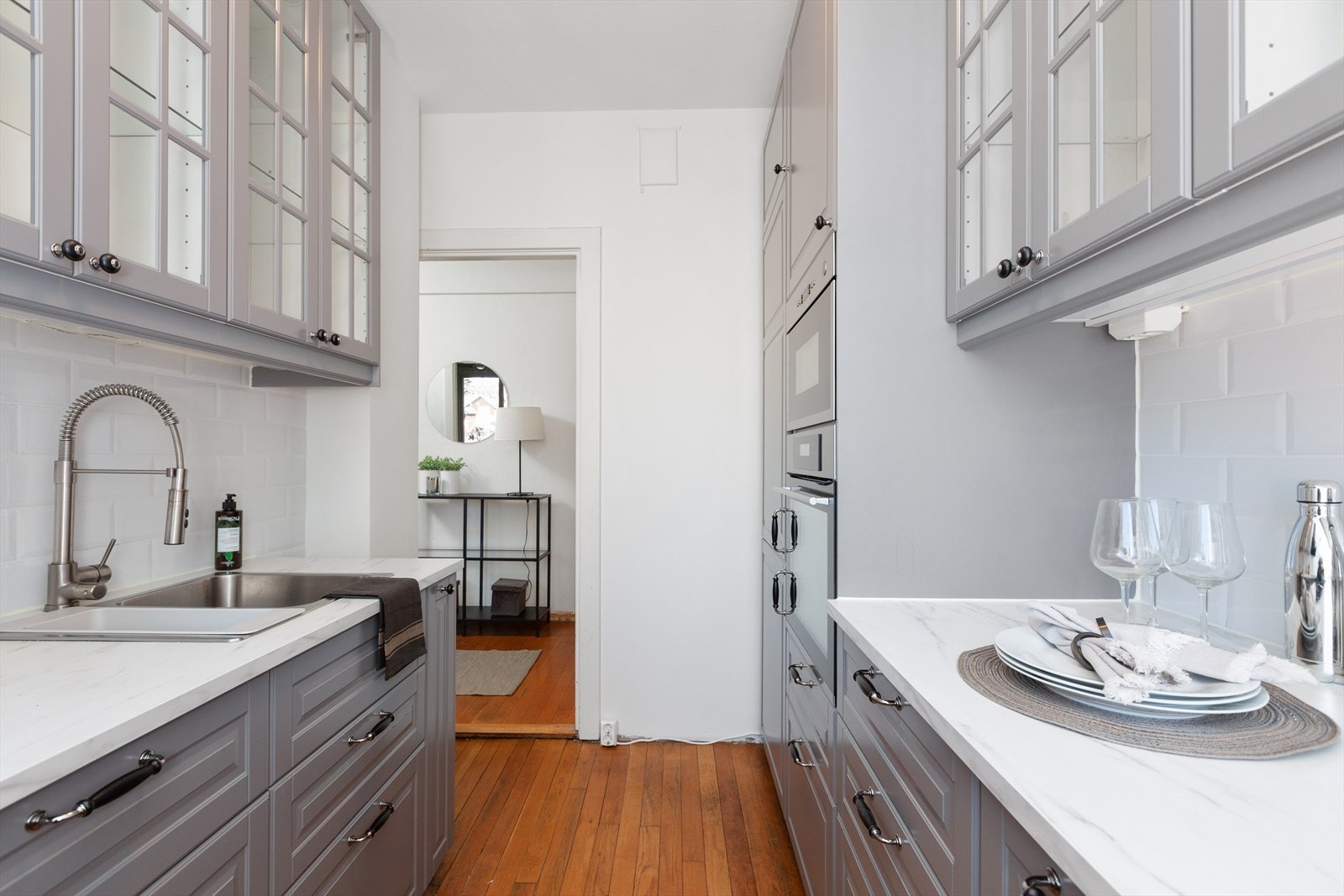 Kjøkkenet har benkeplate av laminert spon, fliser mellom benkeplaten og overskap. Lys under overskapene. Galleribilde