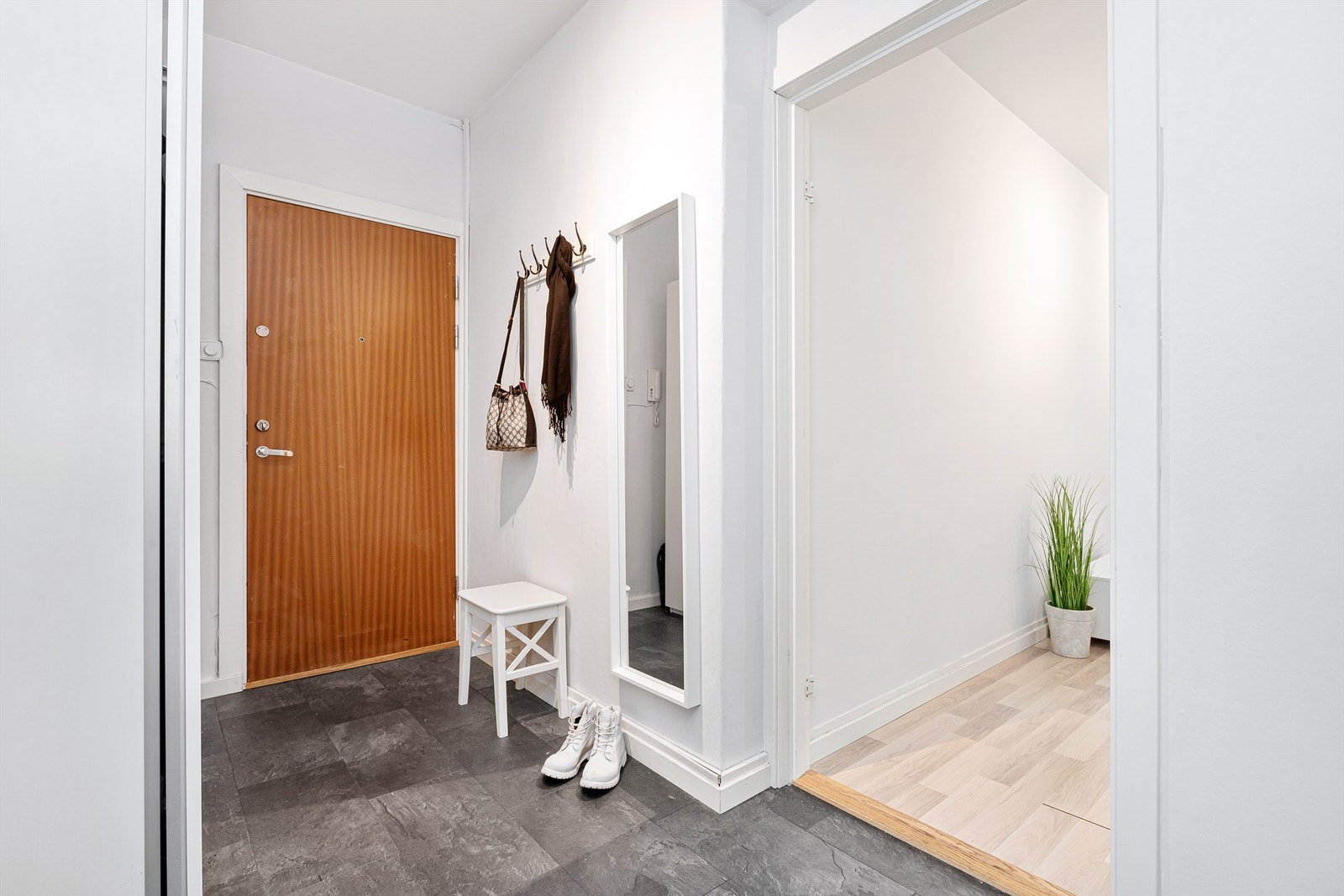 Romslig separat entré med gode oppbevaringsmuligheter i skyvedørsgarderobe og ved knagger Galleribilde