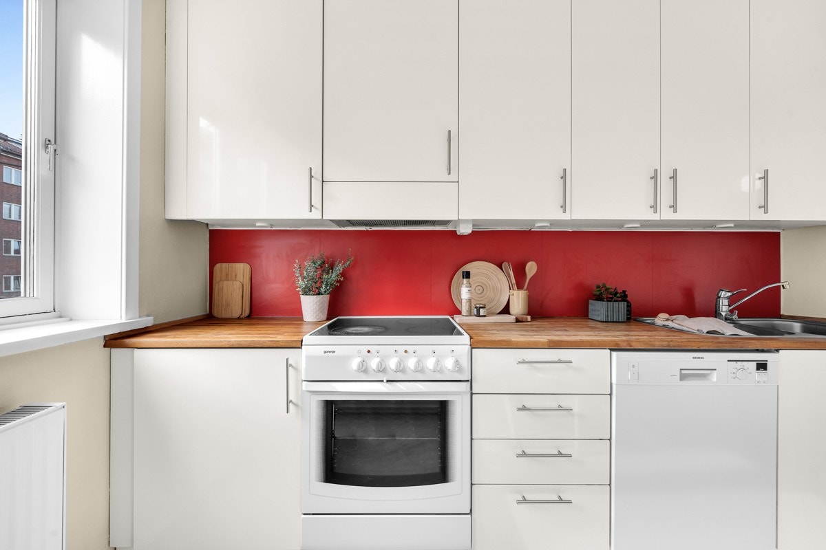 Innredningen har hvite fronter i høyglans, stålhåndtak og benkeplate i heltre med nedfelt vaskekum. Galleribilde