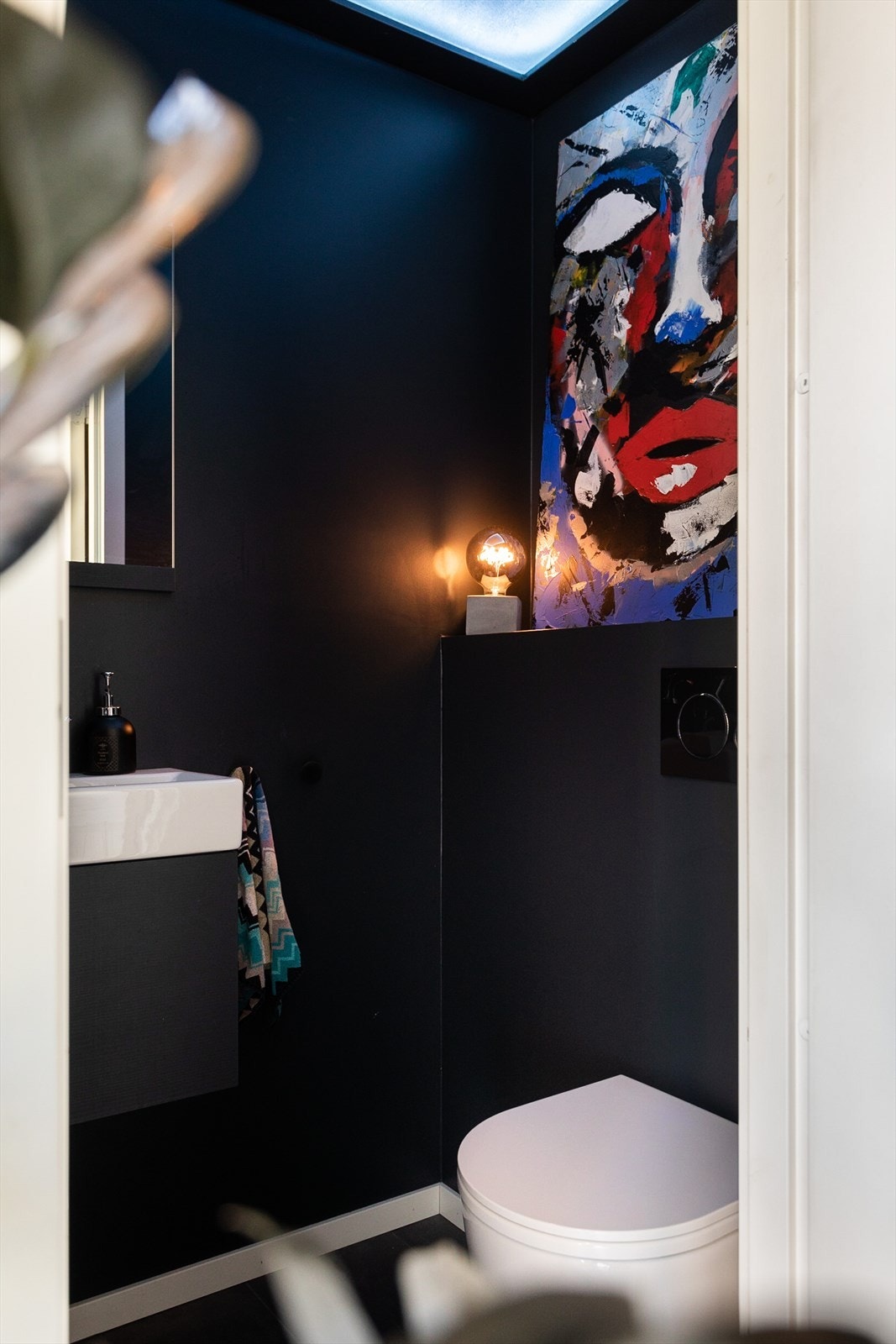 Flislagt toalettrom med varme i gulv oppgradert i 2018. Toalettet består av innredning med glatt skapfront og servant med Damixa ett-greps armatur, speil og stikkontakt på vegg samt vegghengt toalett med Geberit innebygget sisterne. Galleribilde