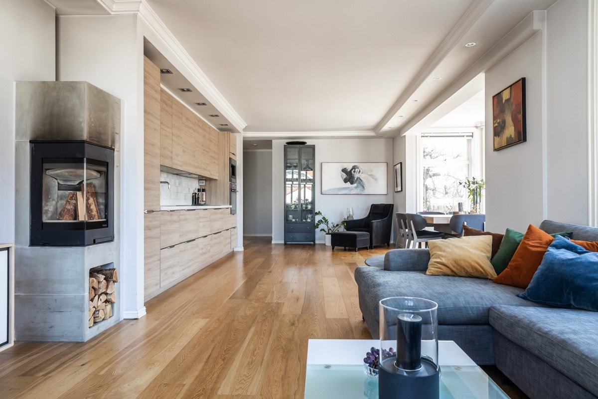 Stor stue med peis, i åpen kjøkkenløsning. Galleribilde