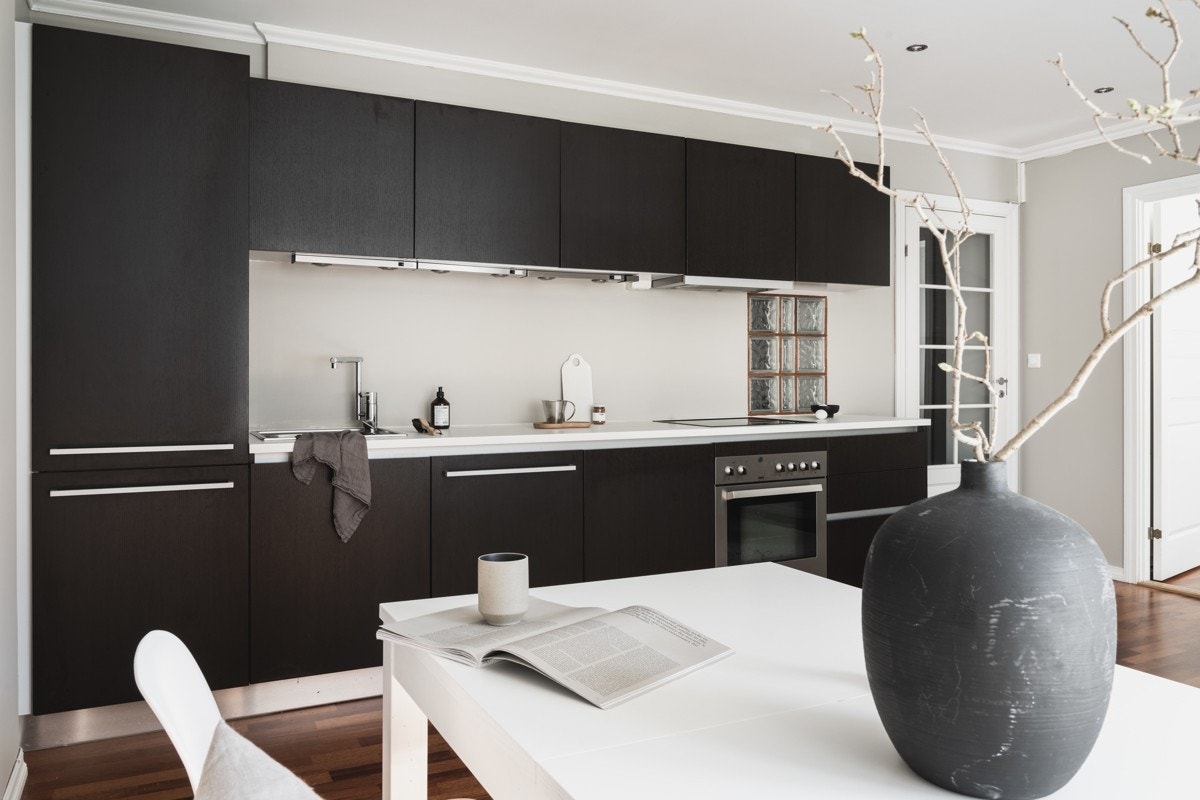 Kjøkkeninnredning med slette fronter og laminat benkeplate med nedfelt vask av stål. Galleribilde