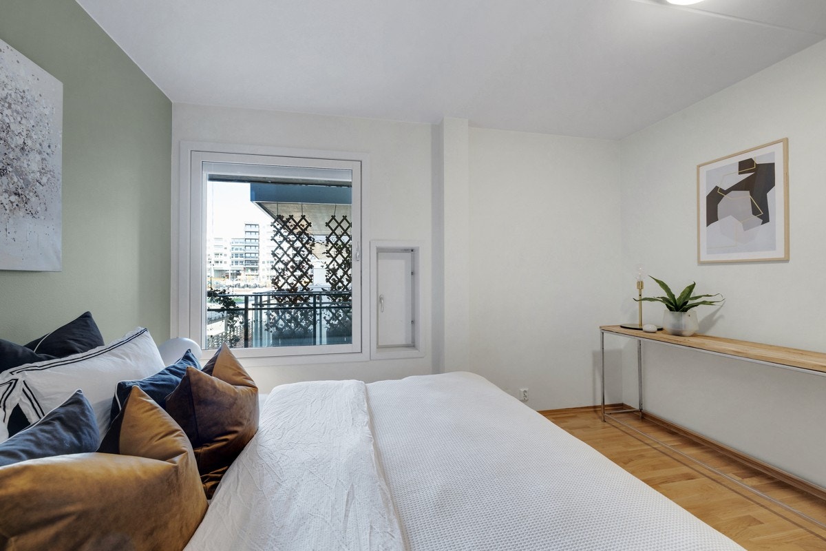 Romslig soverom med god plass til dobbeltseng og tilhørende nattbord Galleribilde