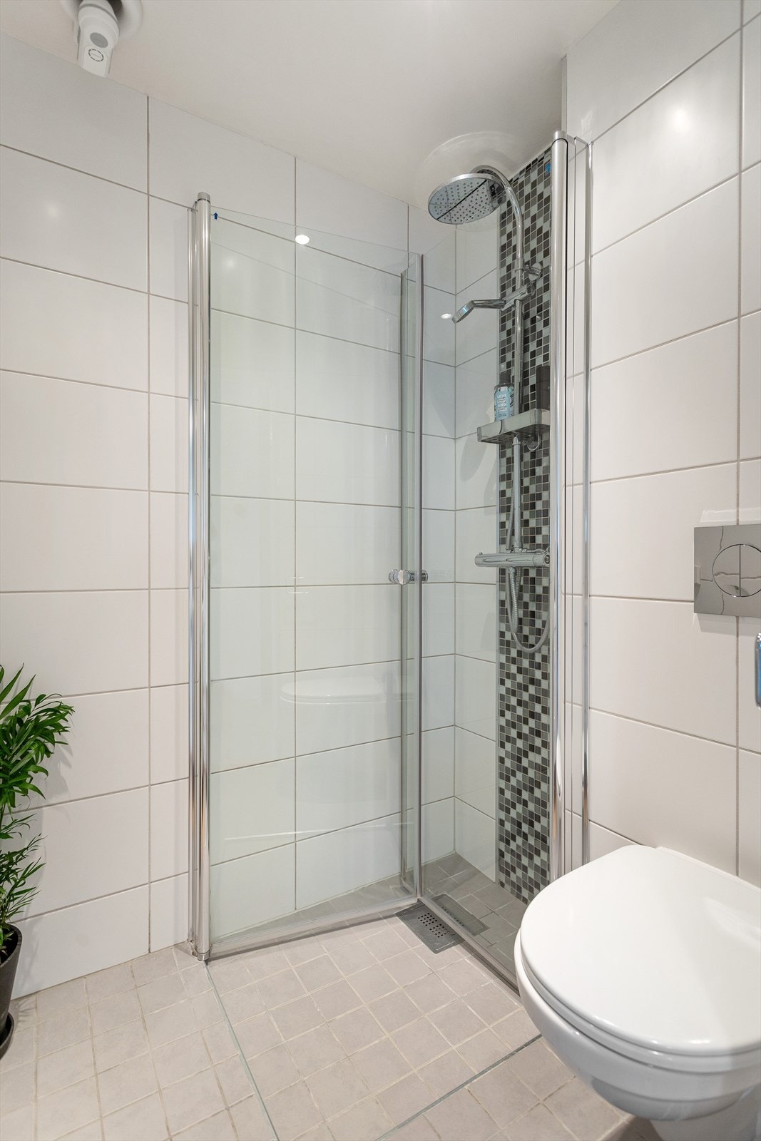 Dusjhjørne med glassdører og to-greps armatur fra Adora, vegghengt toalett fra Gustavsberg og innebygget sisterne fra Gustavsberg. Galleribilde