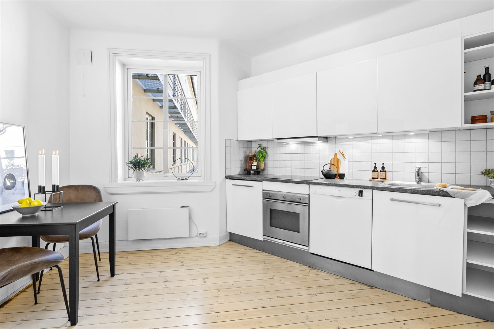 Flott kjøkken med Kjøkkeninnredning av hvite slette fronter og benkeplate av laminat. Belysning over kjøkkenbenk og integrerte hvitevarer. Galleribilde