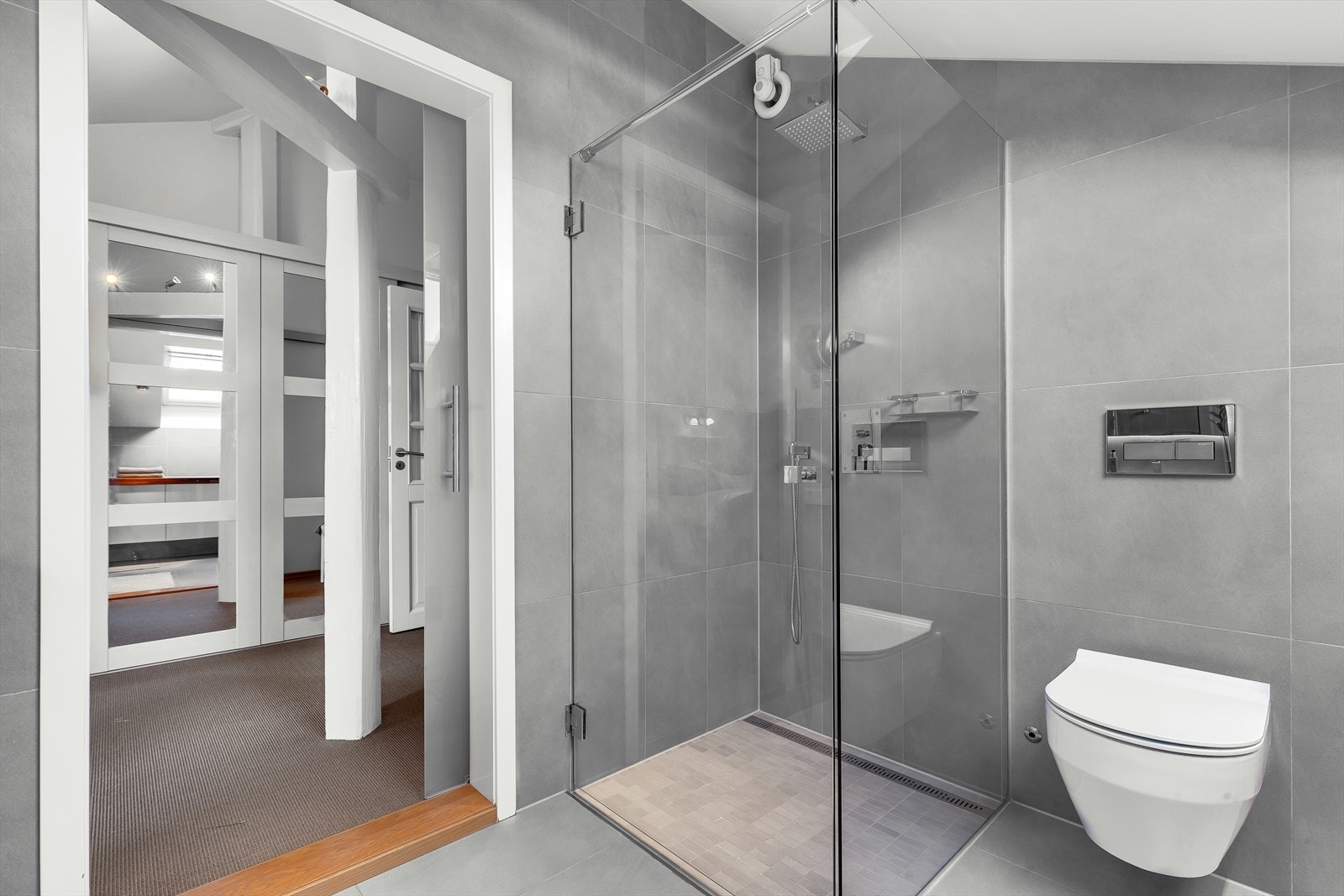 Påkostet og ekslusivt bad med store fliser, vegghengt klosettt og stort dusjhjørne Galleribilde