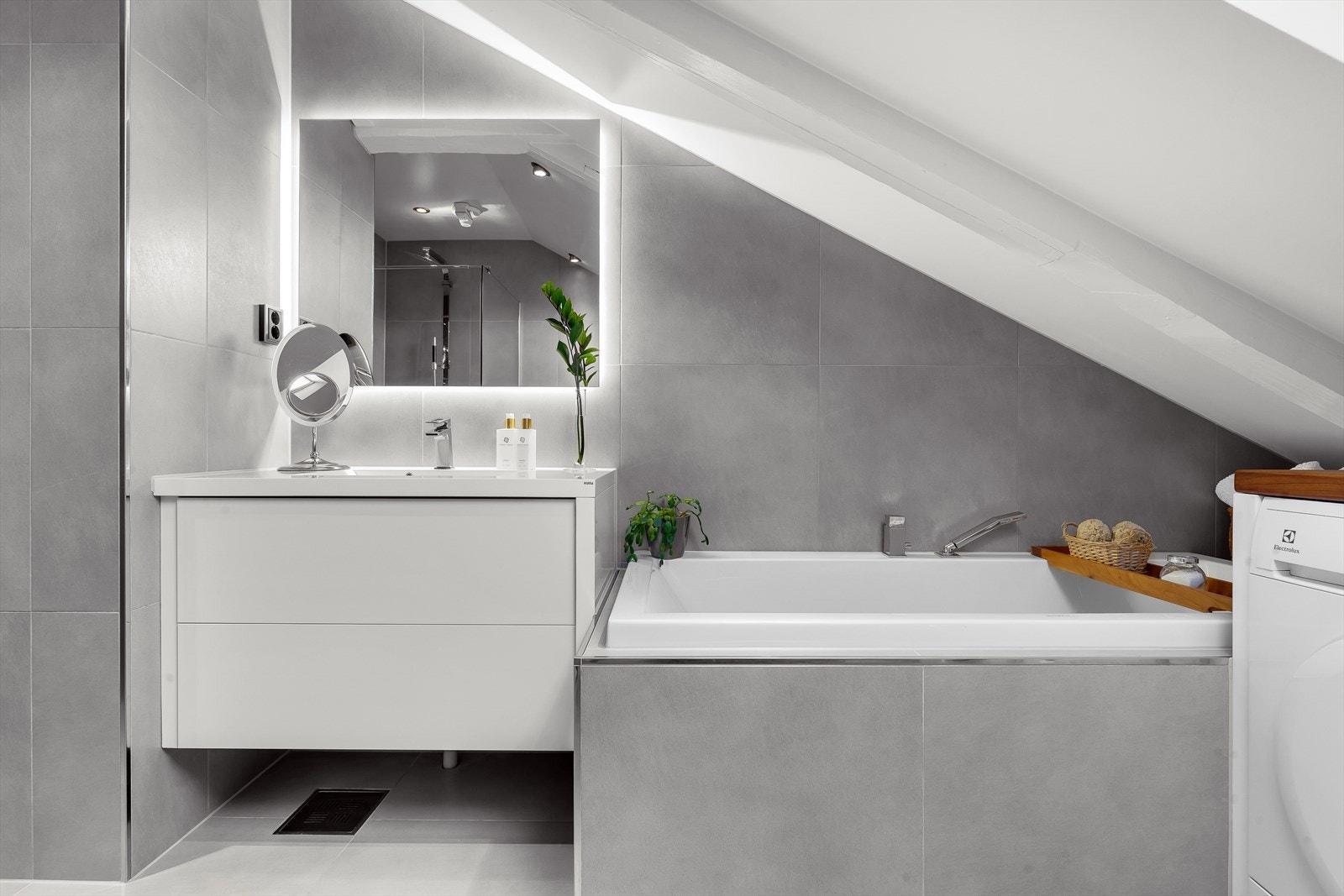 Flott innfliset badekar, servant med underskap og speil med bakgrunnsbelysning Galleribilde