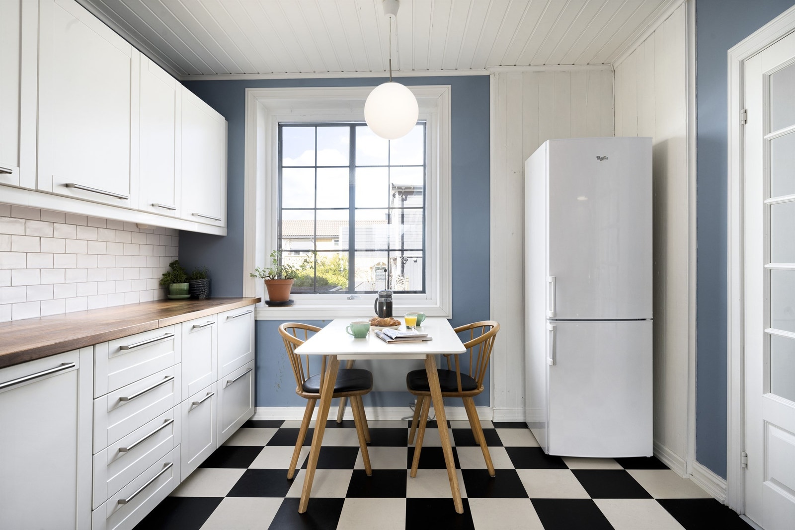 Kjøkken med kork/linoleum i sjakkmønster på gulv, malte vegger og malt panel i himling Galleribilde