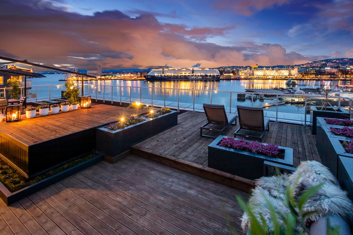 Uterommet er forseggjort med glassrekkverk, Møre Royal terrassebord, nivåforskjeller og blomsterkasser med belysning og helautomatisk vanningsanlegg. Galleribilde