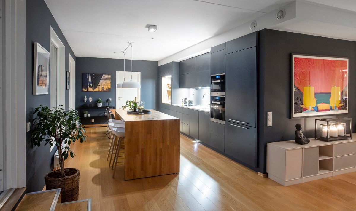 Det er spisebord i eik i forbindelse med en kjøkkenøy - rett rundt hjørnet. Galleribilde