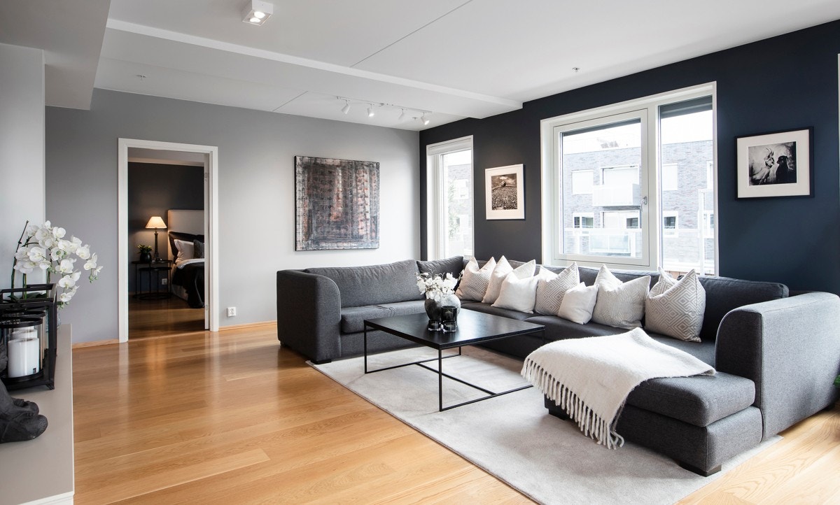 Stuen har eikeparkett på gulv, doble downlights og vegger i grått og blått, som strekker seg listefritt til tak. Den innerste stuedelen er en ypperlig tv-sone. Galleribilde