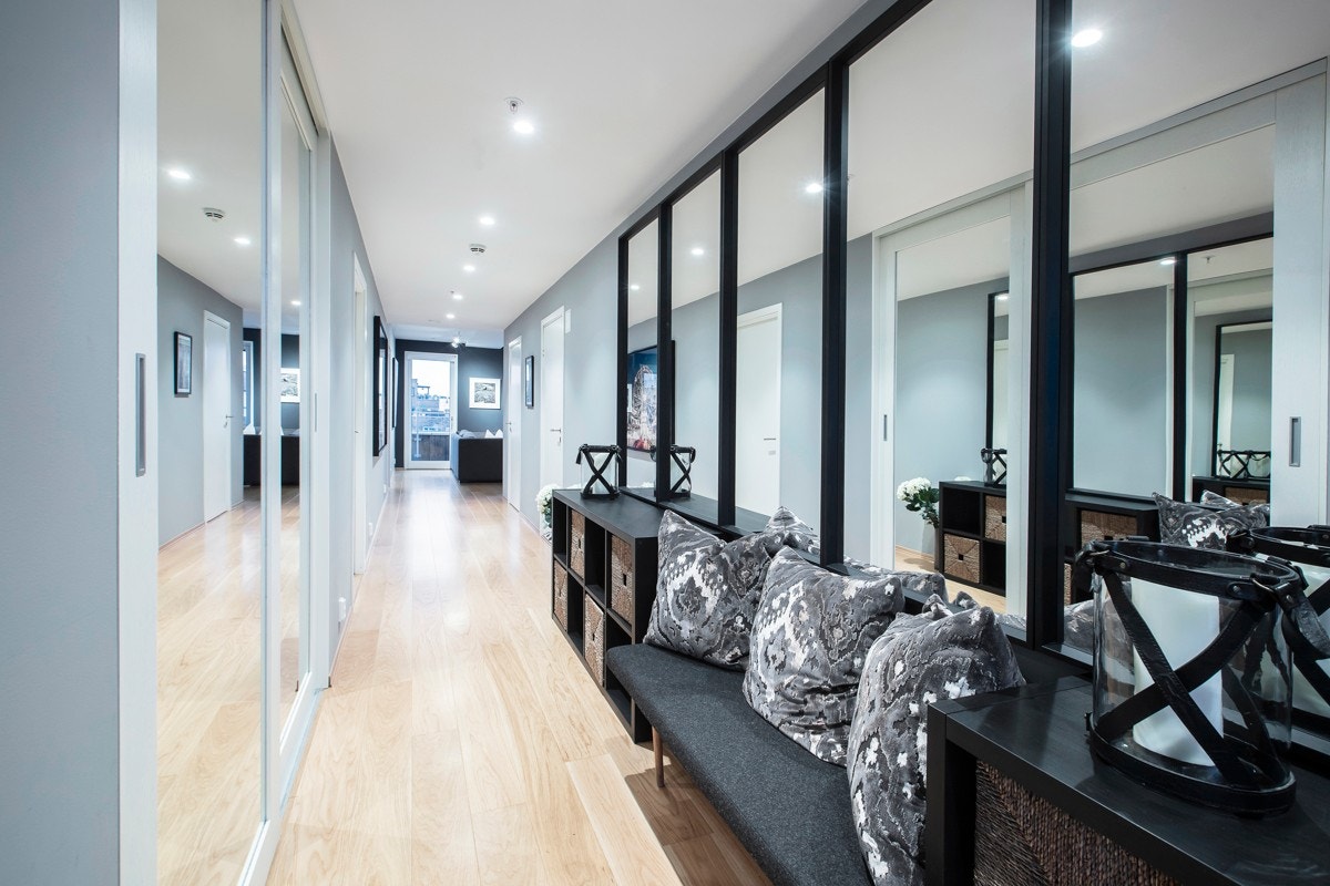 Pent innredet entré med eikeparkett på gulv, downlights i tak og vegger med sval, delikat farge. Det er dørcalling med video og en romslig skyvedørsgarderobe med speilfronter fra Rival, som sørger for fin oppbevaring av alt yttertøy. Galleribilde