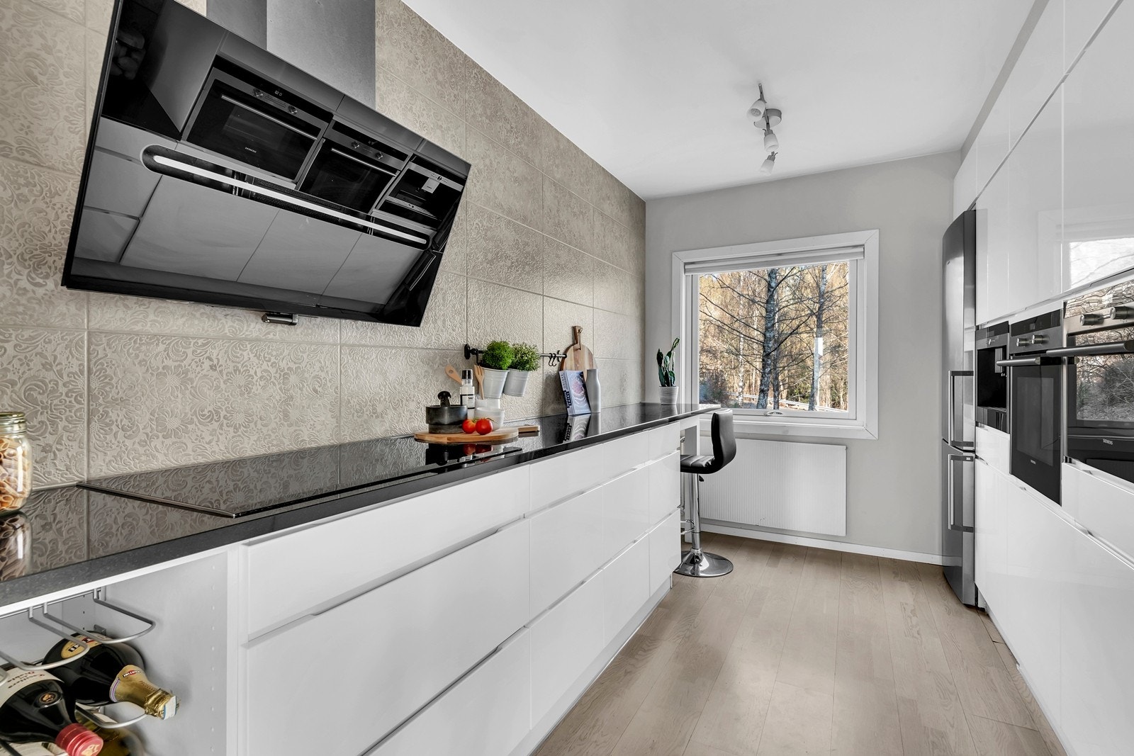 Et velutstyrt kjøkken med integrert ovn, dampovn, induksjons topp og kaffemaskin. Galleribilde