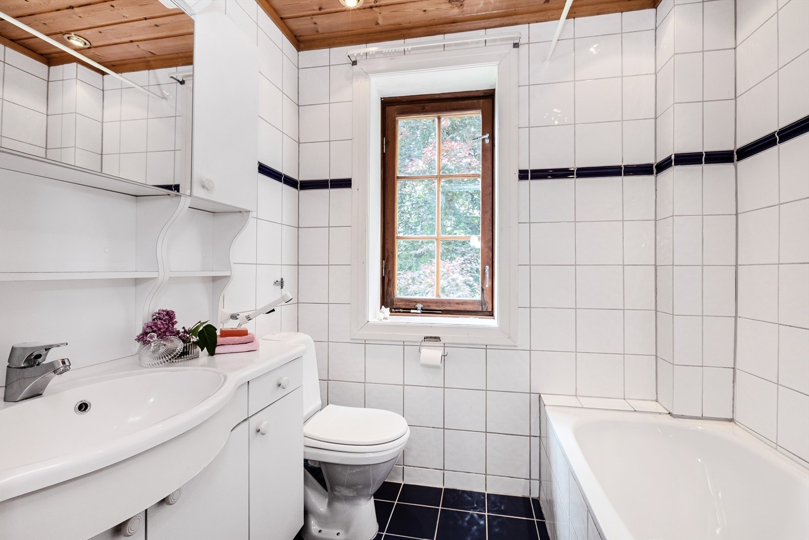 Bad i 2. etasje med servant, skap- og skuffeinnredning og badekar. Galleribilde