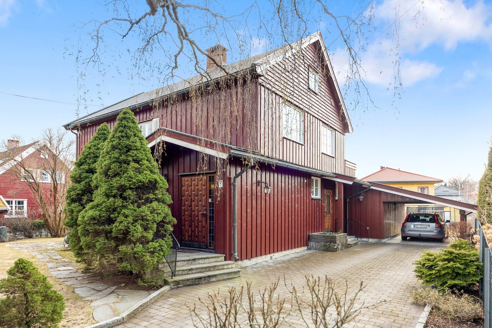 Det er parkering i en tilbygd carport med vippeport Galleribilde