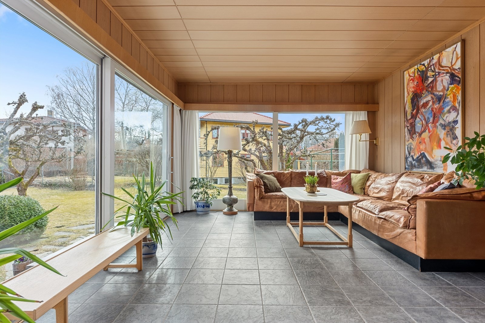 To av veggene er nærmest heldekt av store vindusflater ut mot hagen Galleribilde