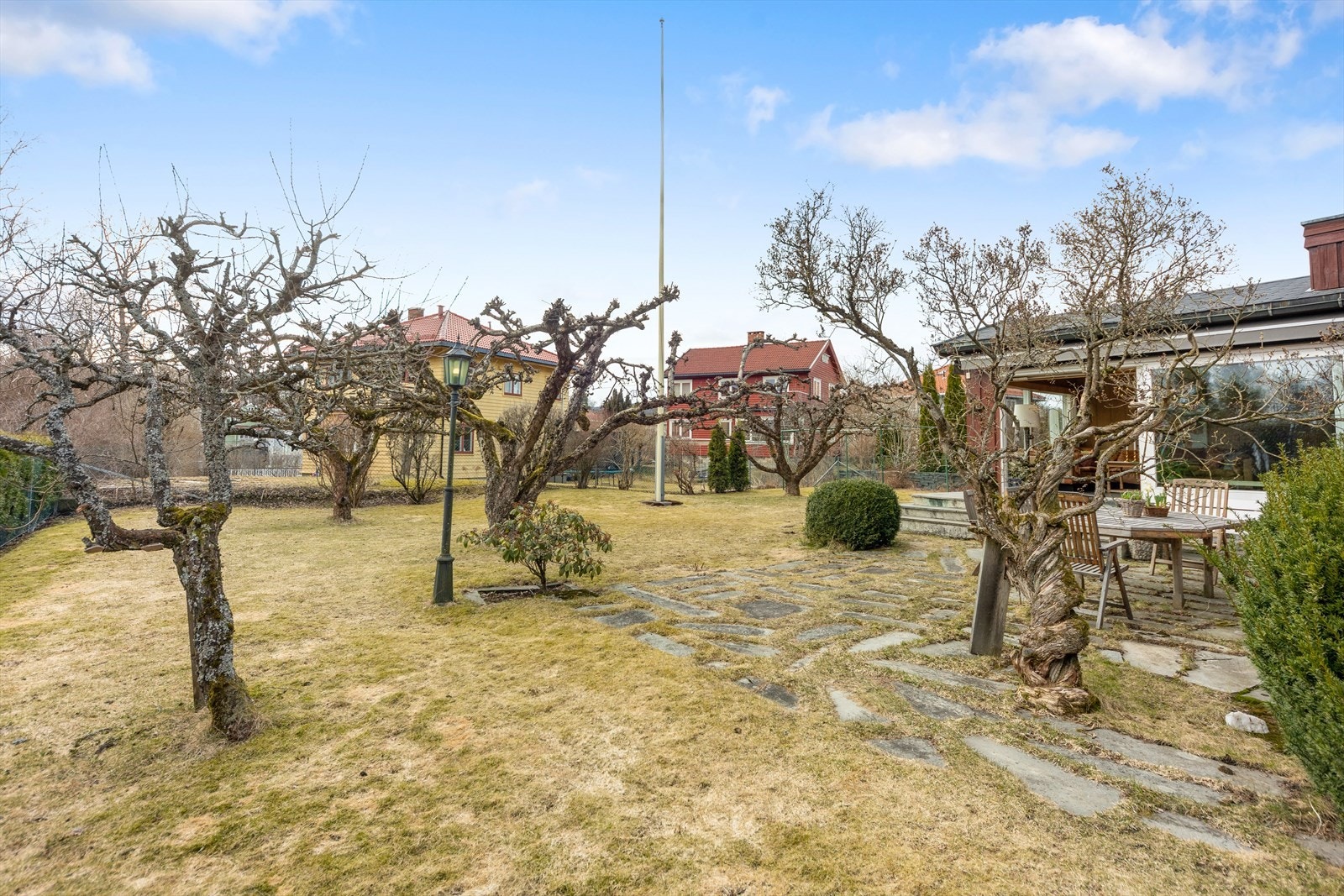 Frodig beplantet hage med gressplen, prydvekster, bed og trær. Galleribilde