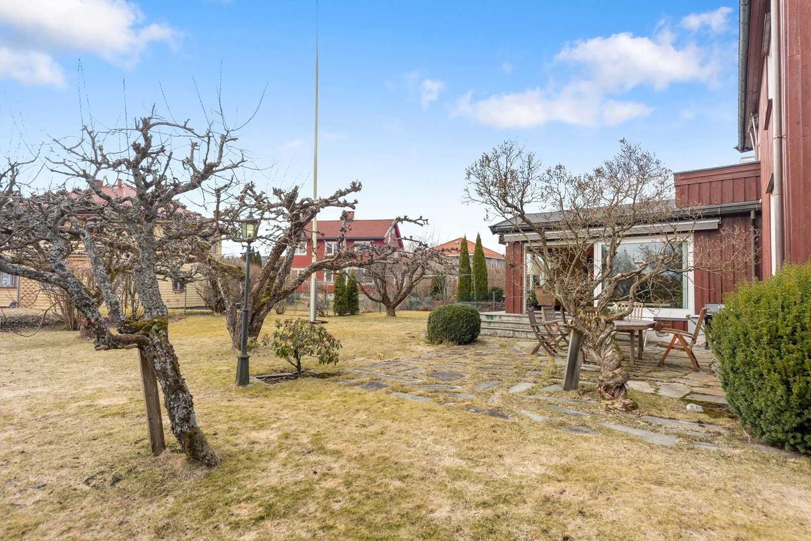 Gjennom hagen snor det seg gangstier med steinheller, som munner ut i et større areal foran stuen. Galleribilde