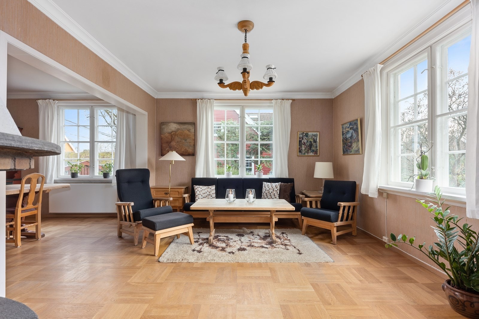 I peisestuen er det god plass for sofa og lenestoler foran en murt teglsteinspeis med vednisje og åpen grue Galleribilde