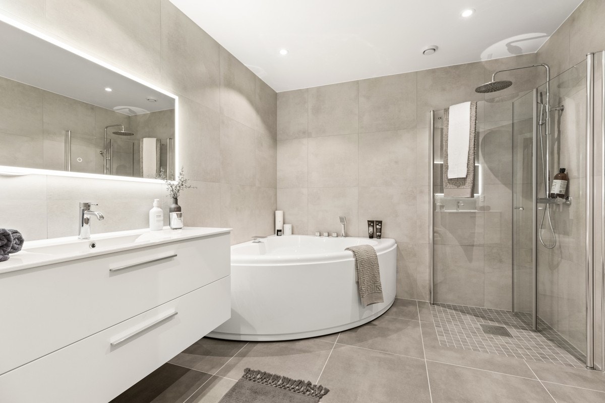 Stort, hellfiset bad i underetasje med varmekabler i gulv og downlights i himling. Galleribilde