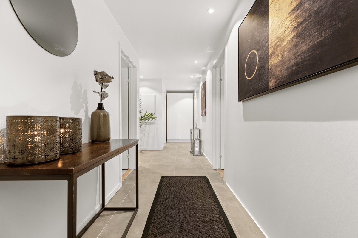 Entré/hall i underetasje med lekre 60x60 fliser på gulv, downlightsbelysning og plass for garderobeløsning. Galleribilde