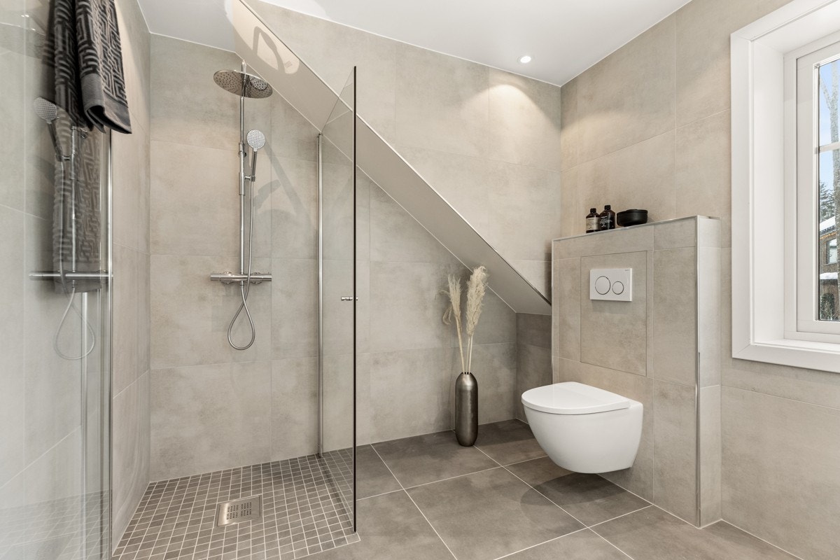 Dusjhjørne med mosaikkflis på gulv, innfellbare glassdører og behagelig regnfallsdusj fra Tapwell. Galleribilde