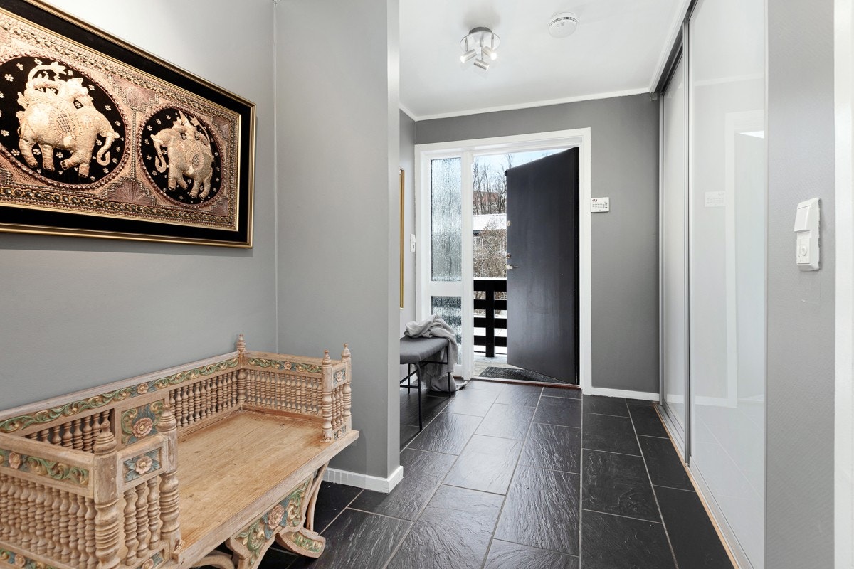 Entré med varmekabler, sorte skiferfliser og skyvedørsgarderobe. Galleribilde