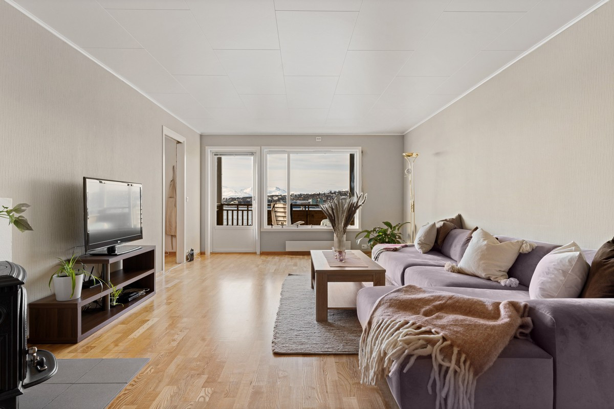Leiligheten har stor stue med naturlige soner for sofagruppen og spisebordet.