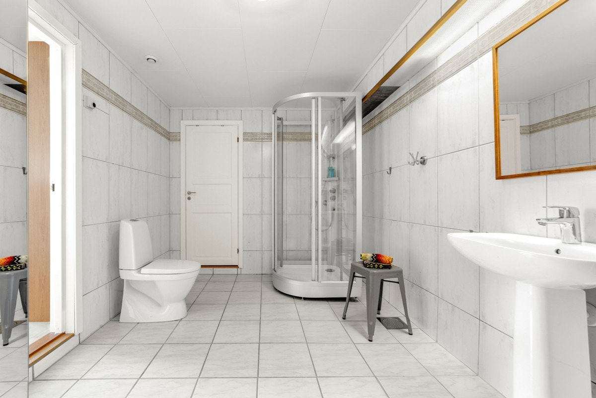 Romslig flislagt bad med adkomst fra soverom. Dør inn til lagringsbod Galleribilde