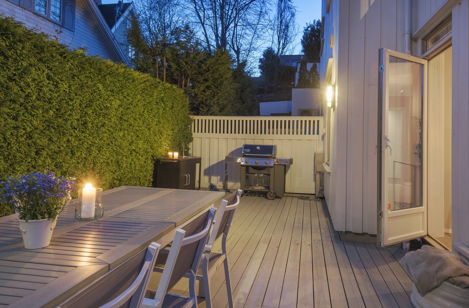 Levegg og høy hekk mot naboeiendommer. Merk deg utekjøkkenet og grillplassen lengst bort på terrassen. Galleribilde