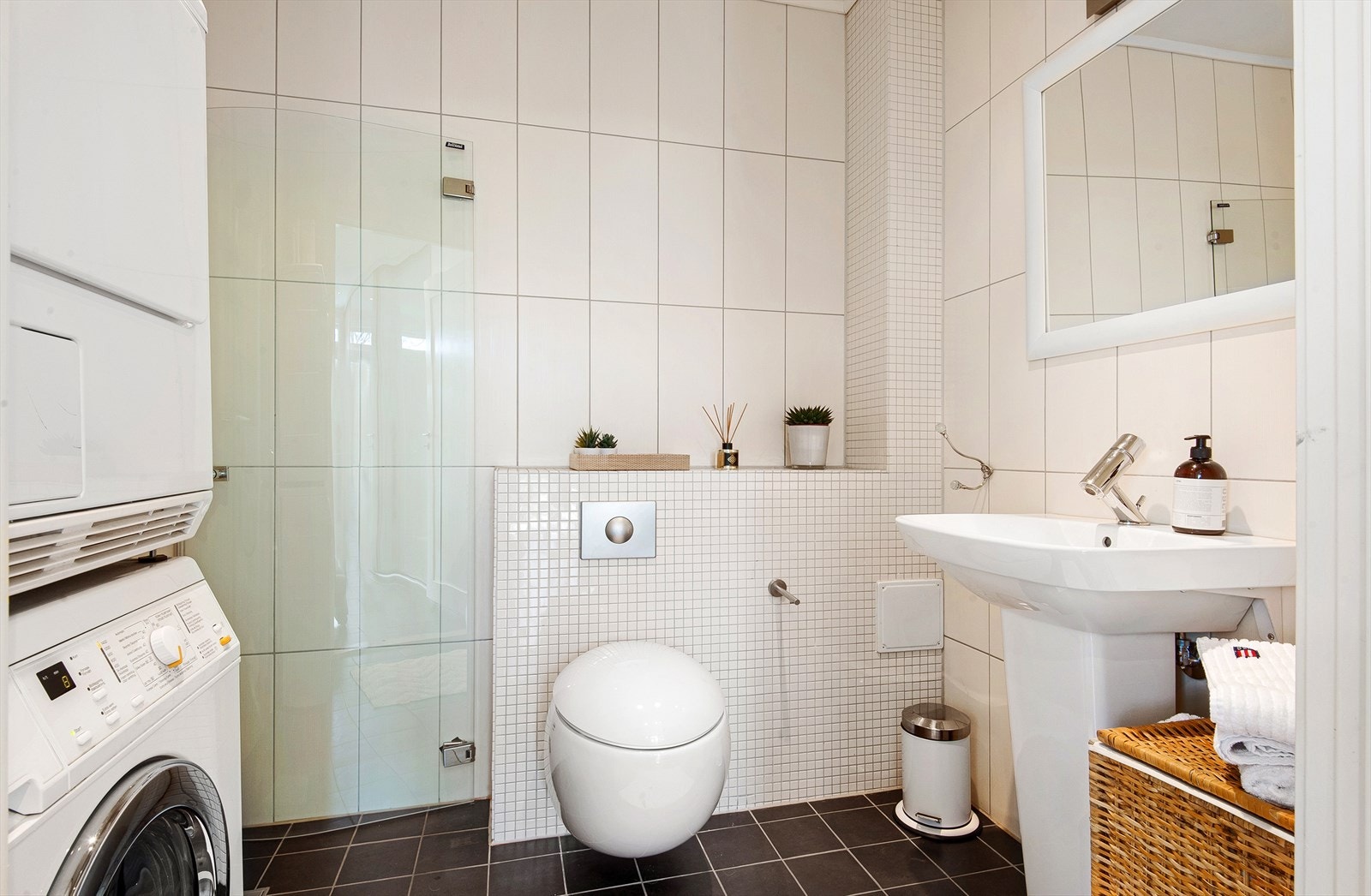 Baderom i 1.etg med dusjhjørne med dører i herdet glass. Søyleservant og vegghengt toalett. Speil og lys over servant. Kran og strømuttak for vaskemaskin/tørketrommel. Galleribilde