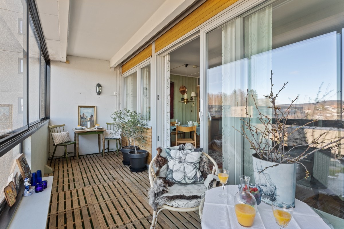 Adkomst fra stue til innglasset balkong med gulvareal på ca.10.m². Balkongen er belagt med trelemmer. Galleribilde