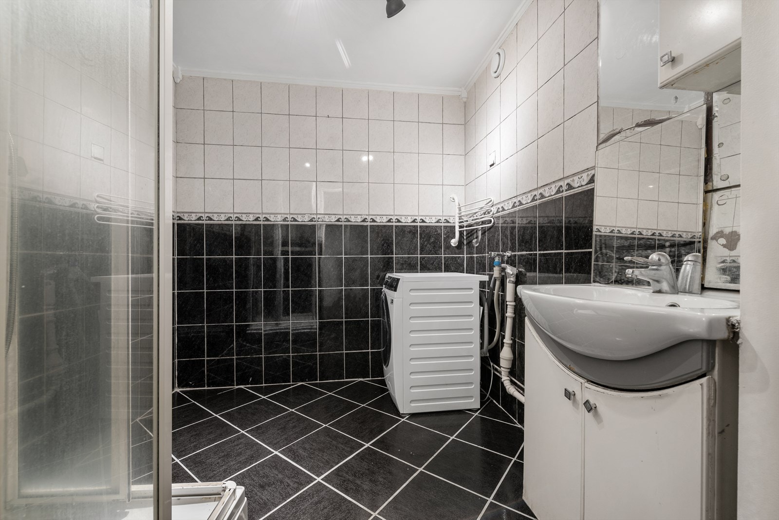 Flislagt baderom med opplegg for vaskemaskin. Galleribilde