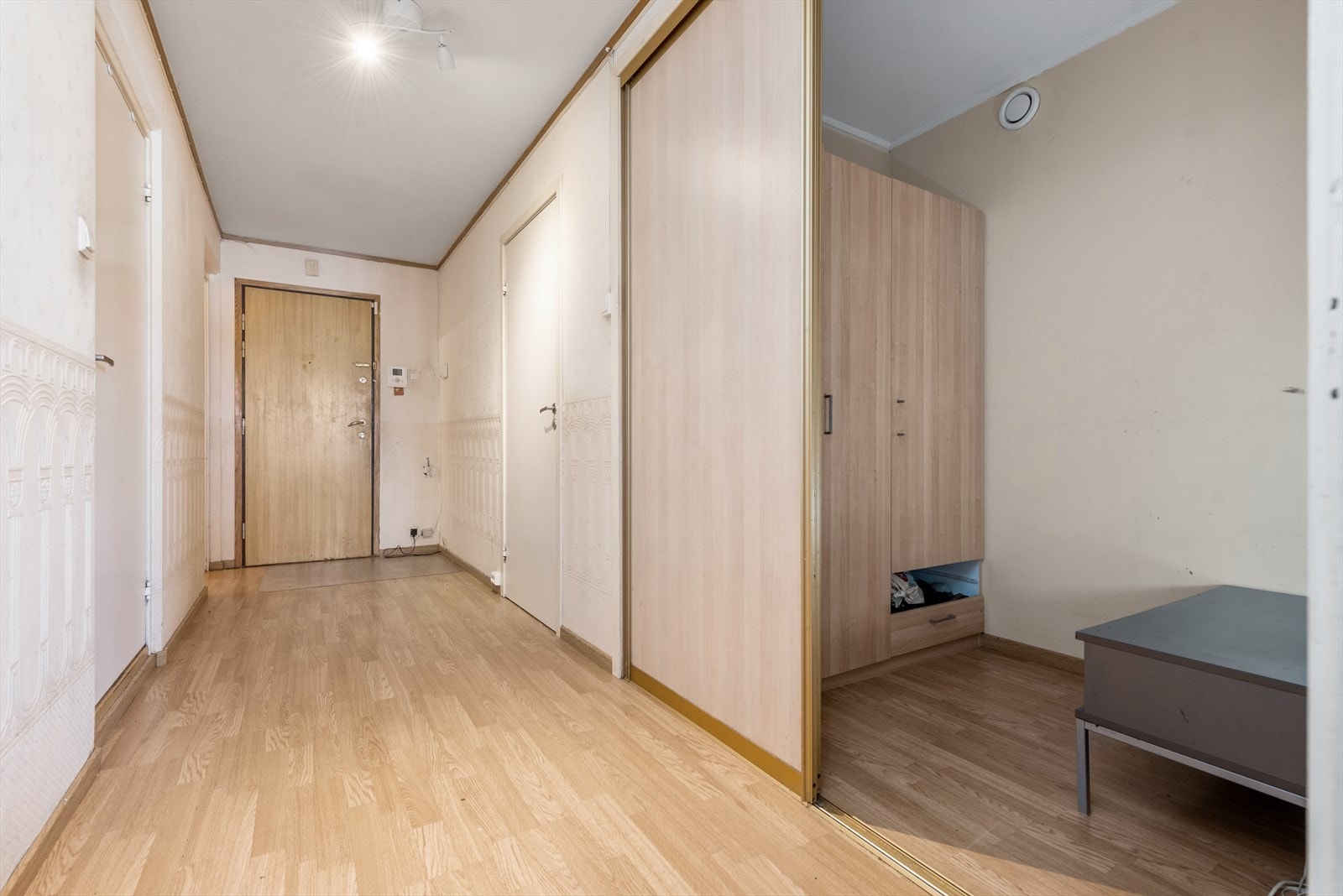 Man kommer inn i en romslig entré med god plass til å henge fra seg i innvendig bod/walk-in closet med skyvedør. Galleribilde