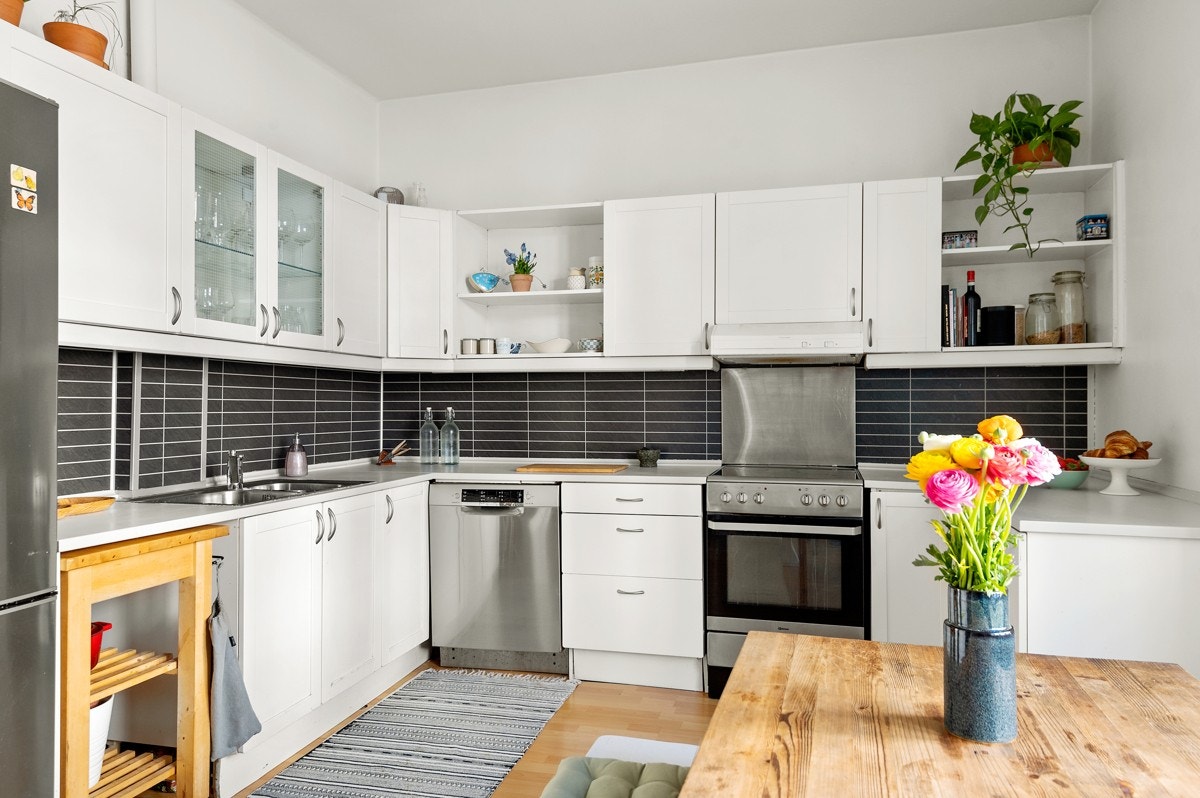 Kjøkkeninnredning med hvite profilerte fronter og lys heltre benkeplate (pusset og malt i 2021) med nedsenket oppvaskkum. Her har du rikelig med skap- og benkeplass! Det er også plass og opplegg for vaskemaskin. Galleribilde