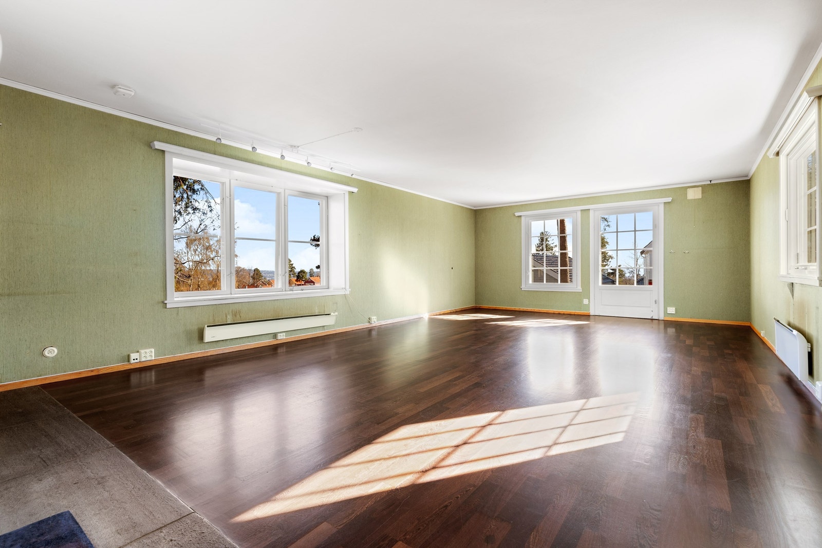 Åpen og stor stue i første etasje med naturlig lys fra 3 yttervegger. Her er det utgang til terrasse og hage. Åpen peis sentralt i rommet Galleribilde