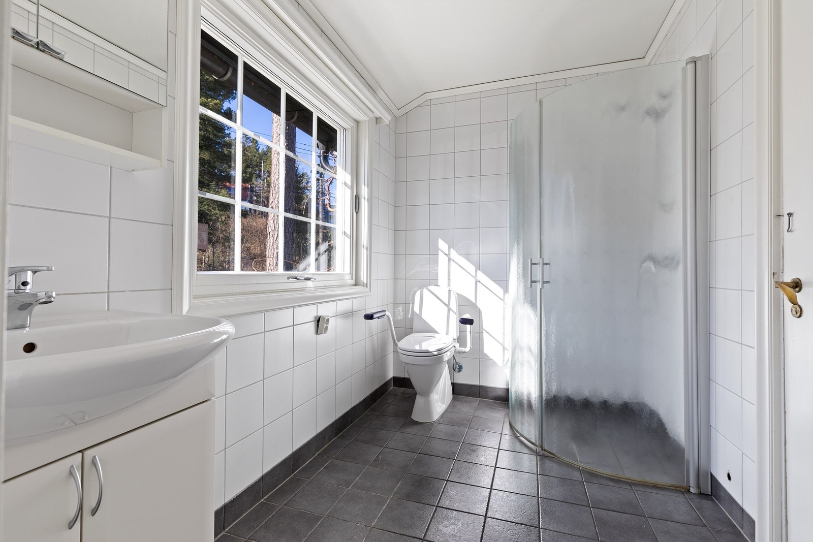 Lyst og flislagt baderom med gulvvarme Galleribilde