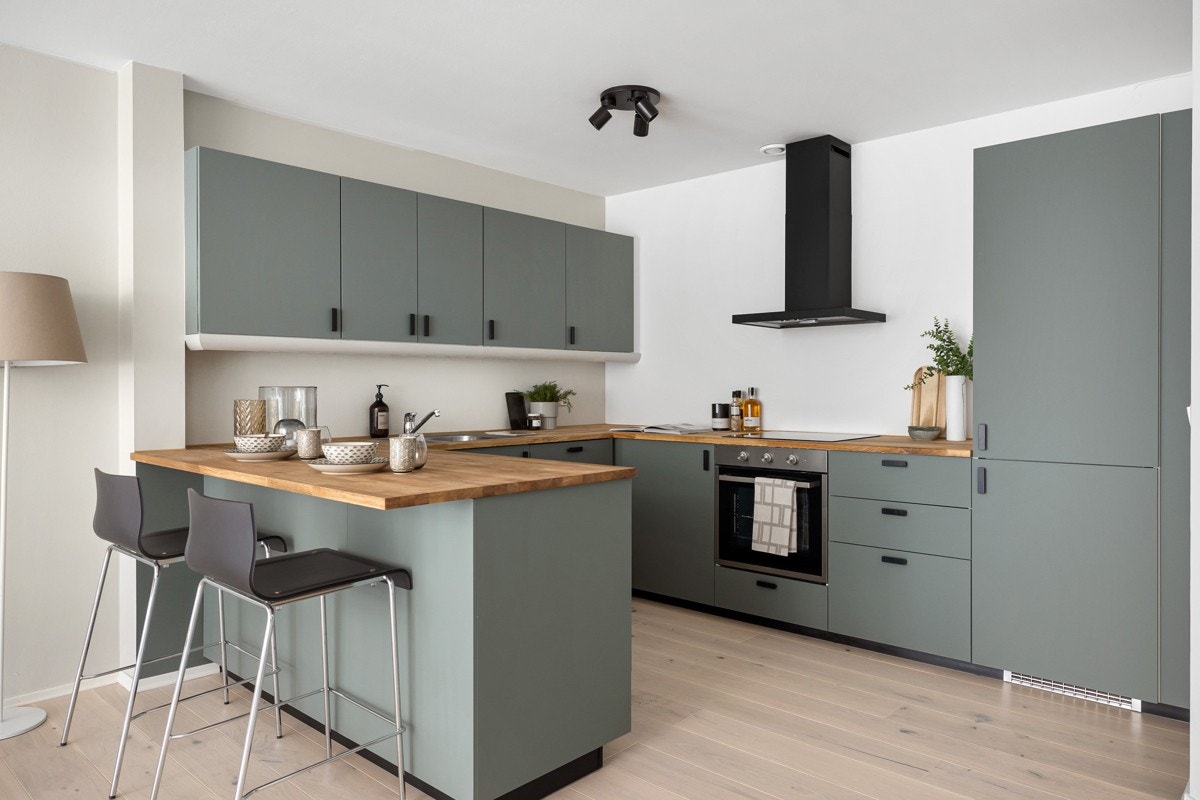 Kjøkkenet er utstyrt med helintegrerte hvitevarer som induksjon platetopp, stekeovn, kjøle-/ fryseskap og oppvaskmaskin Galleribilde