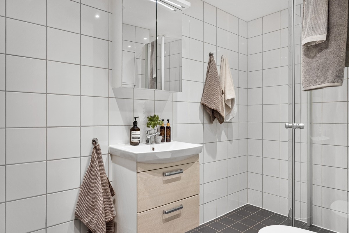 Tidløst og innbydende flislagt baderom som ble pusset opp i regi av sameiet i 2014. Galleribilde