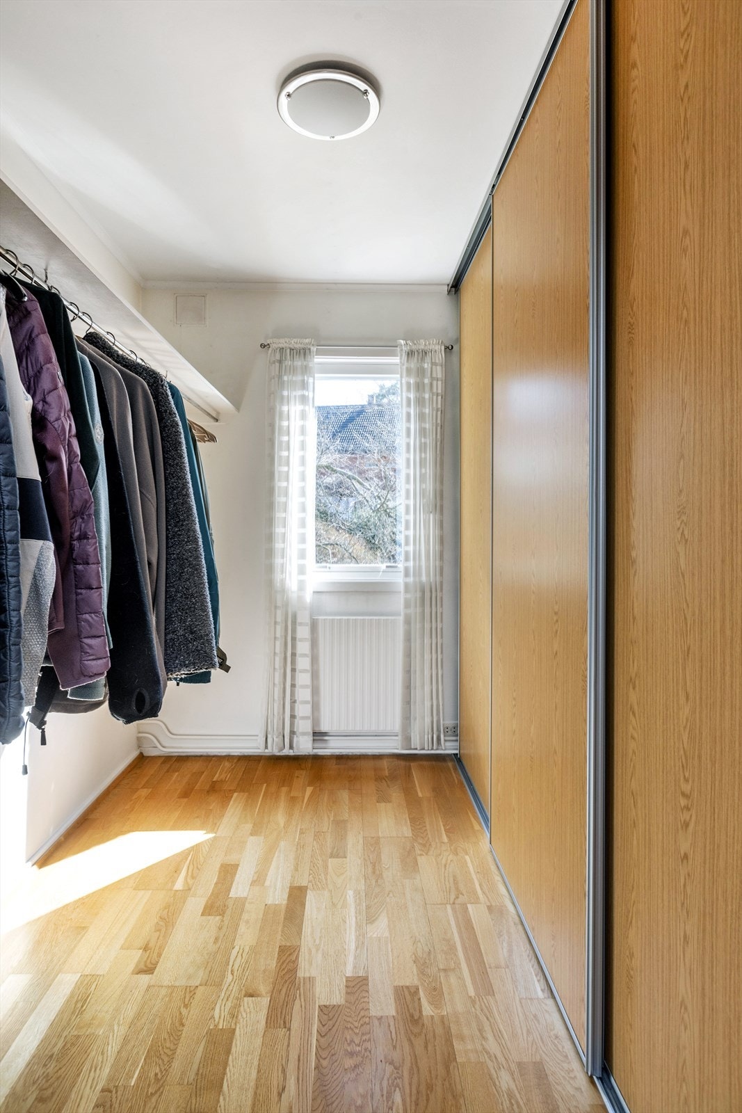 Garderoberom med stor skyvedørsgarderobe. Galleribilde