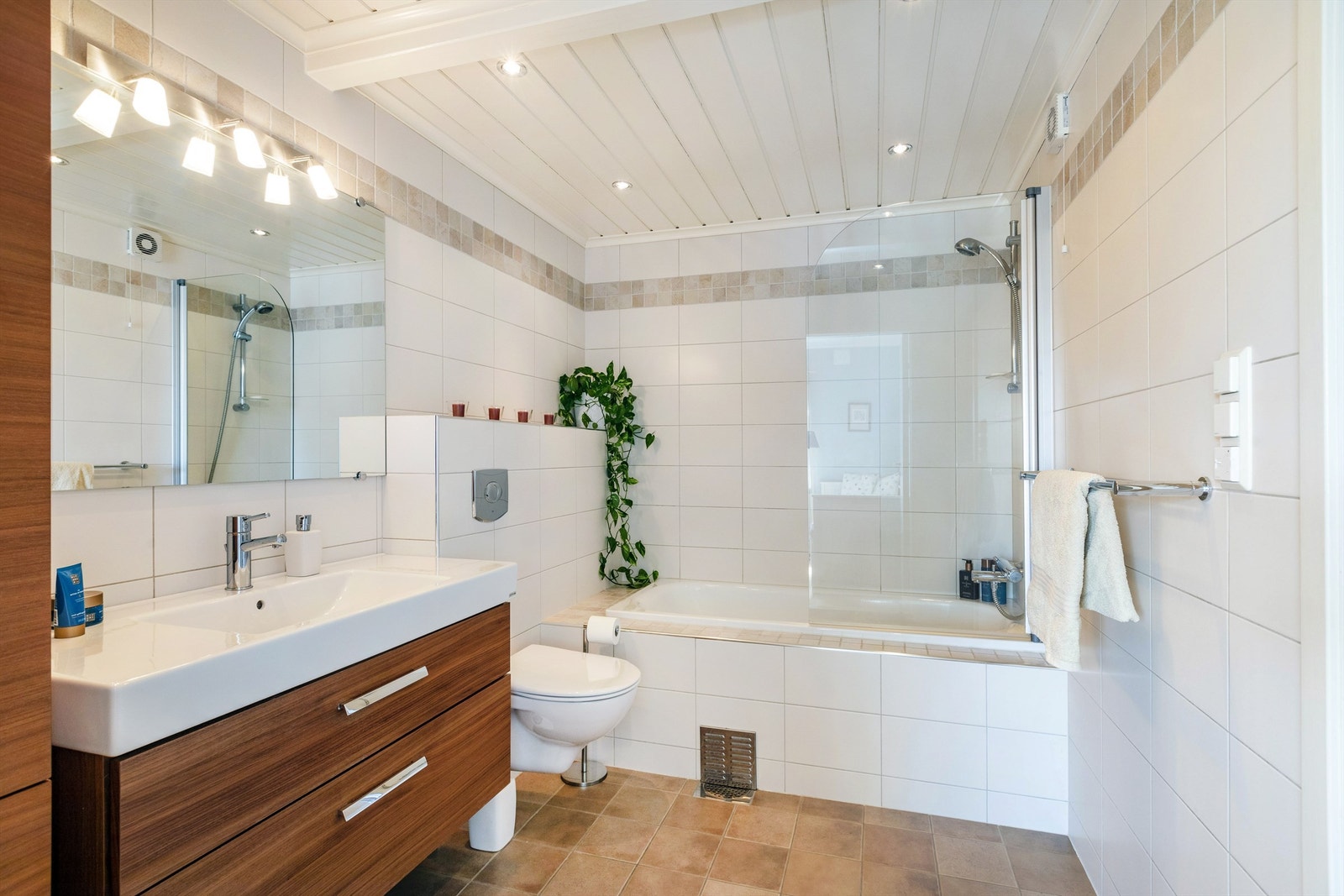 Pent flislagt bad pusset opp i 2006 med innmurt badekar, innfellbar glassvegg, vegghengt toalett og servantskap med speil. Det er gulvvarme på badet. Galleribilde