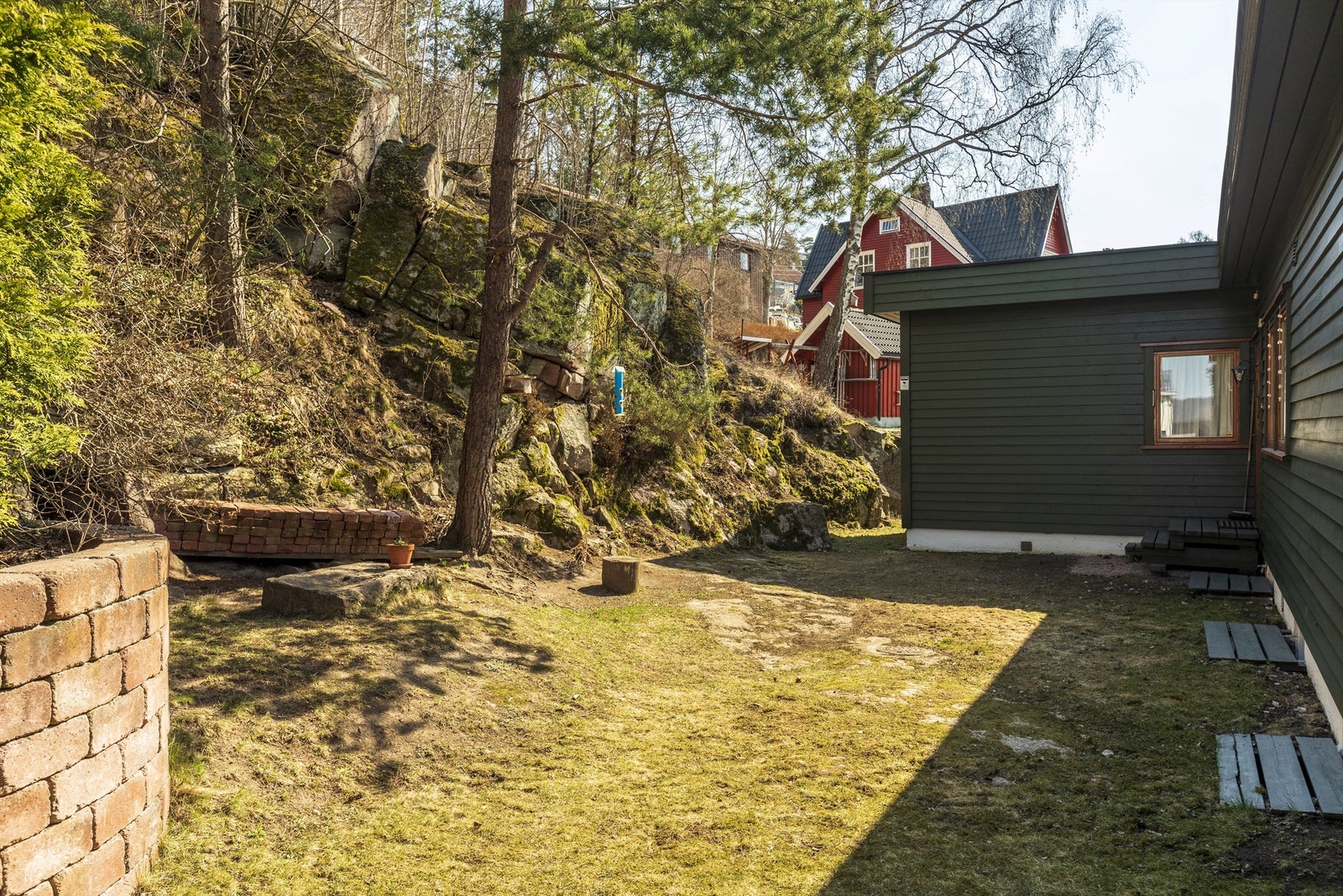 Her er det en gressplen og naturtomt med trær og klatremuligheter i skråning. Galleribilde