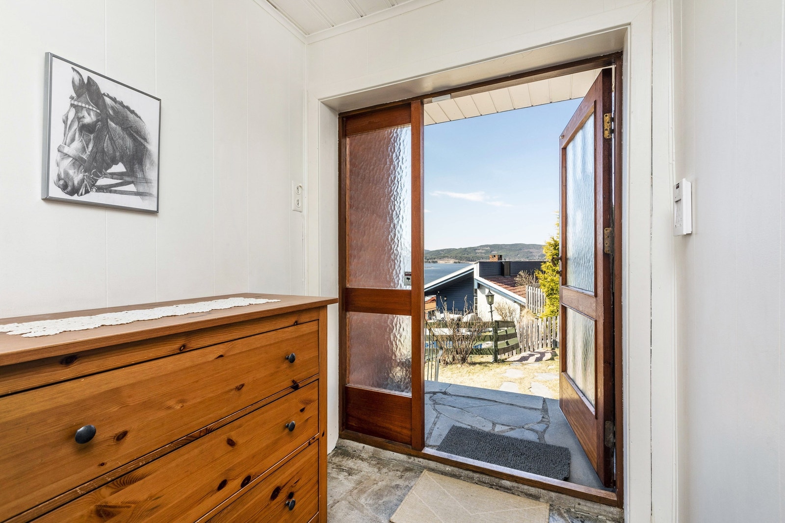 Vindfang med skiferfliser på gulv og garderobeplass i skap. Galleribilde