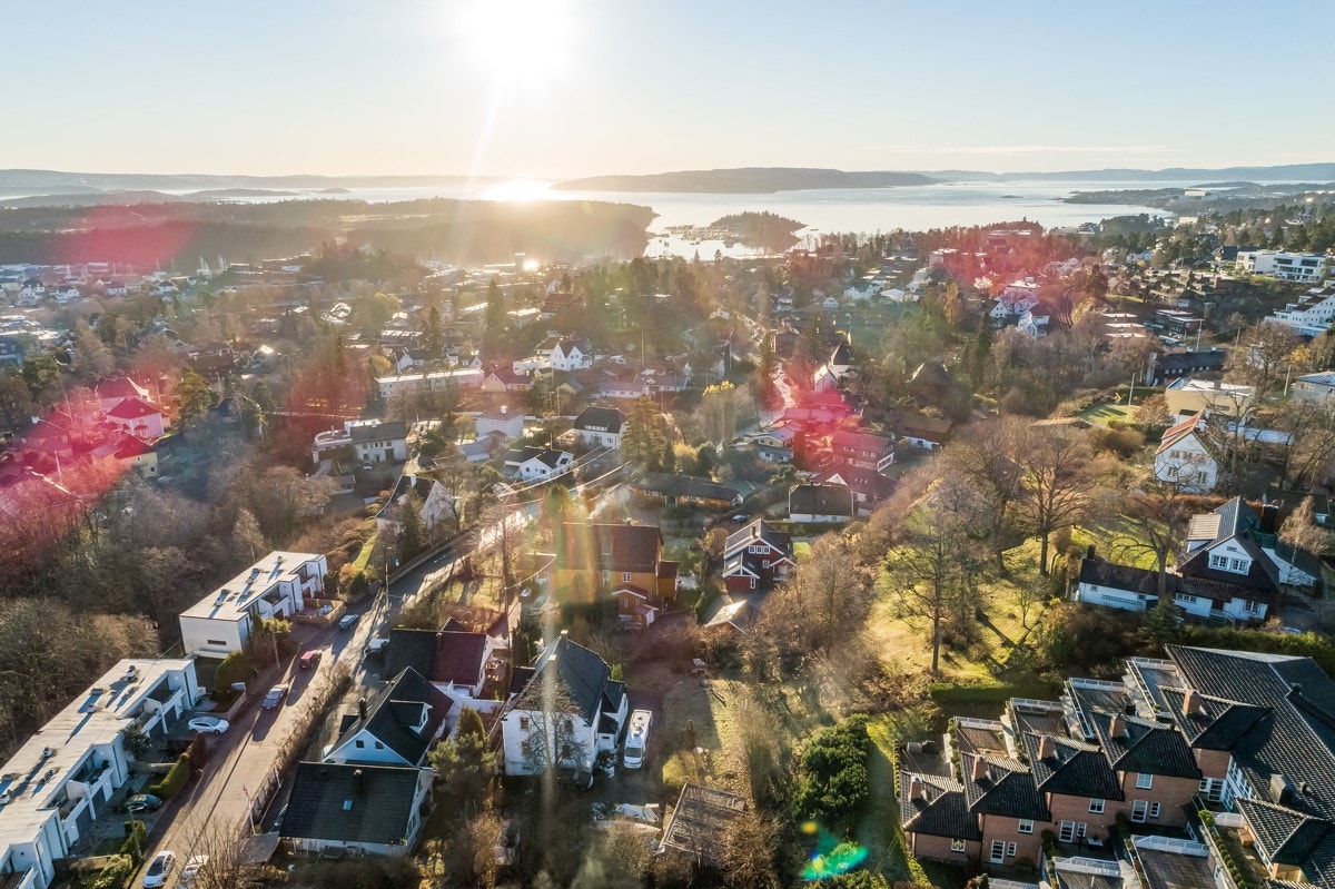 Et luftig dronebilde hvor boligen sees nede til venstre i bildet. Galleribilde