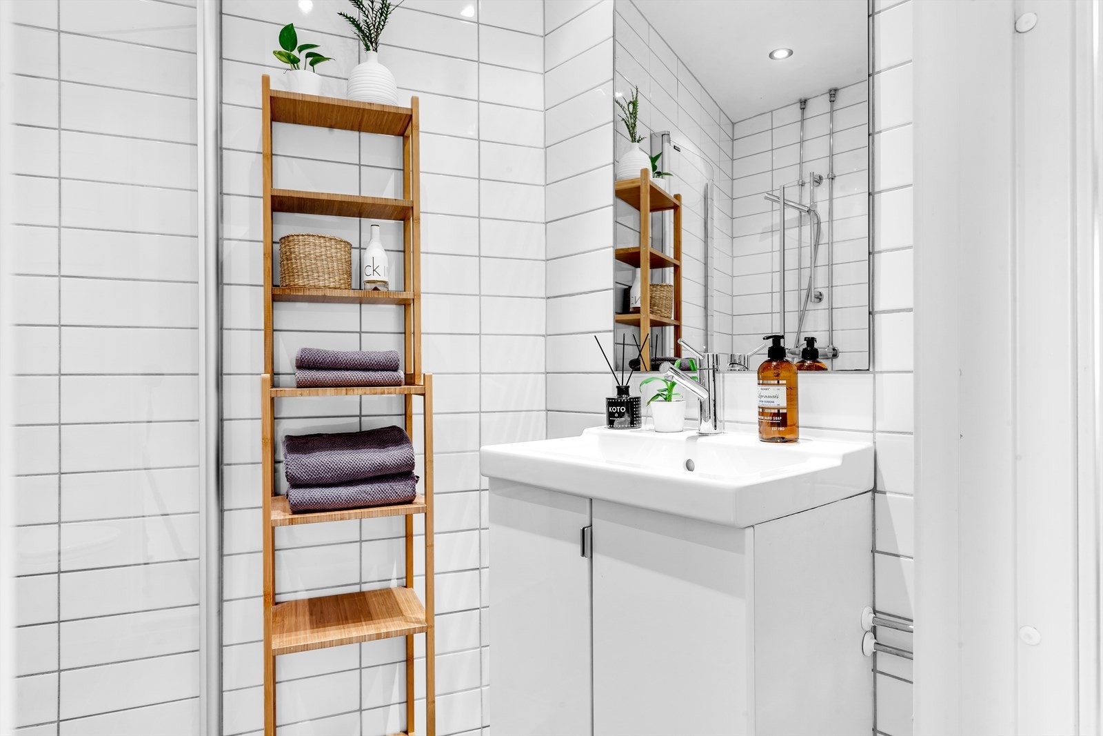 Baderommet inneholder veggmontert wc, dusjplass med vegger og servant med ettgreps blandebatteri i innredning. Galleribilde