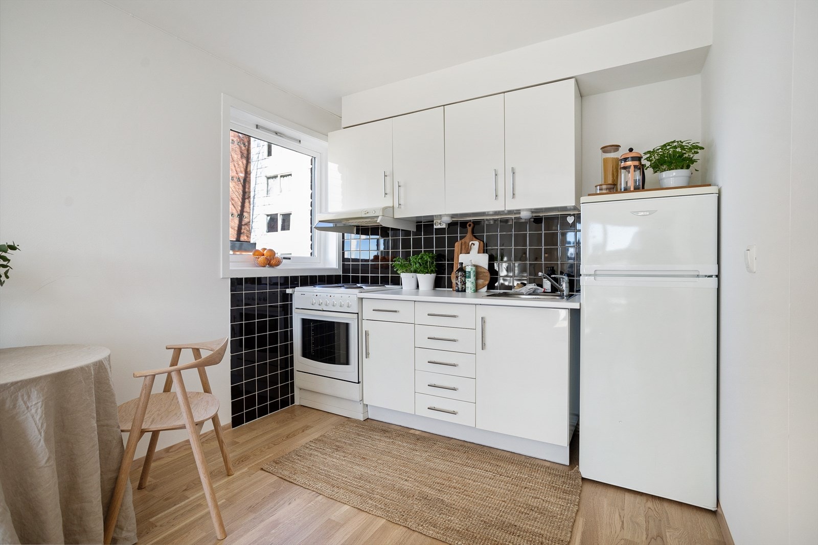 Her har du en tidsriktig kjøkkeninnredning med hvitevarer som komfyr, platetopp og kjøleskap med fryser. Galleribilde