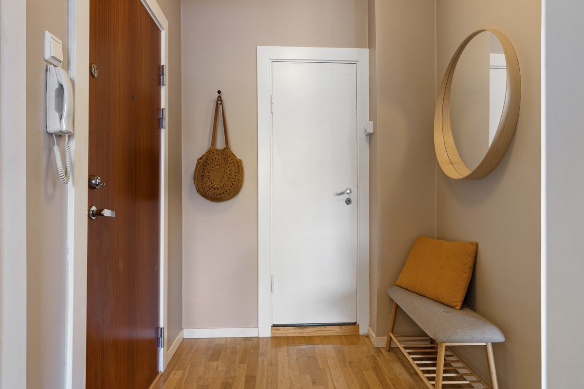 Entréen tar deg vel i mot med lyse og delikate farger og plass til yttertøy og sko Galleribilde