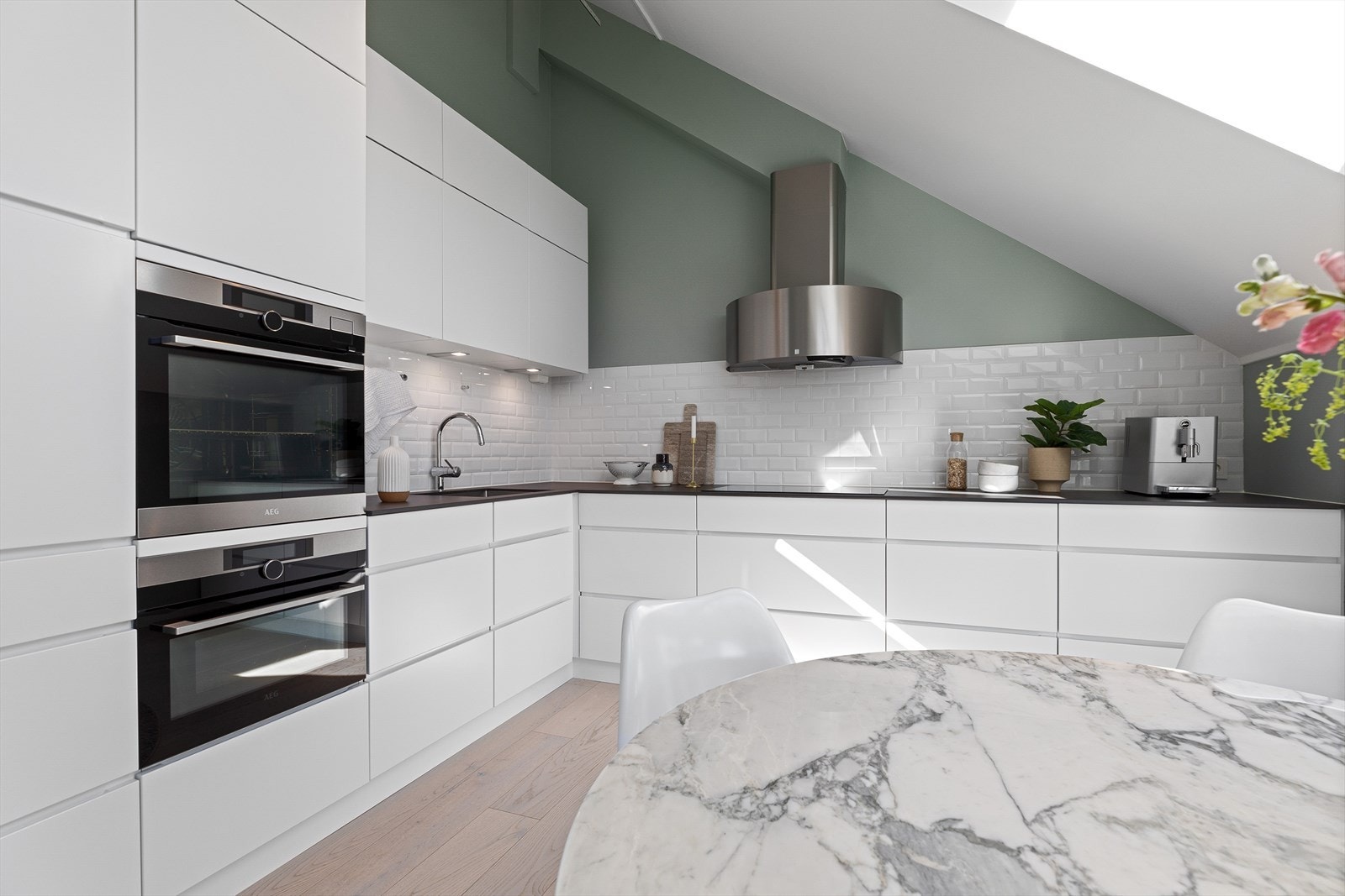 Innredning fra 2018 med glatte fronter, benkeplate i stein og flislagt mellom benkeplate og overskap Galleribilde