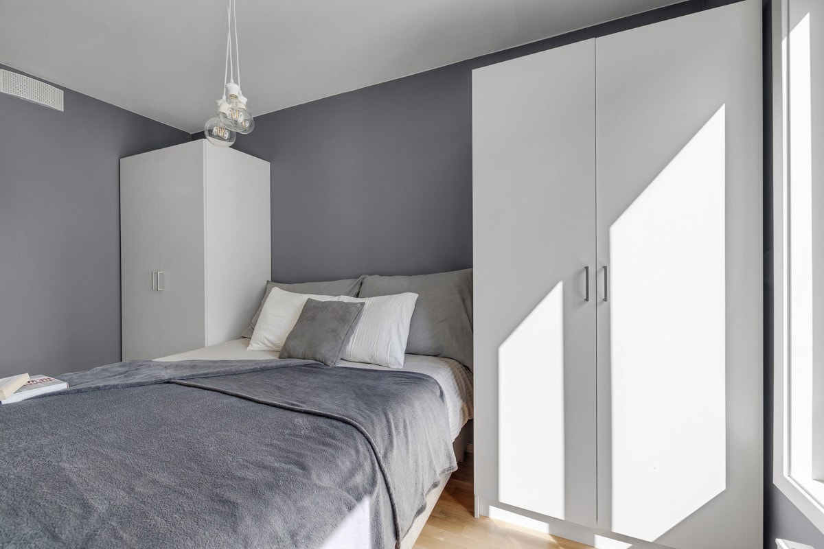 Lyst og innbydende soverom som vender ut mot rolige fellesarealer uten biltrafikk. God og moderne standard med eikeparkett på gulv og glatte lysmalte overflater. God plass til en stor dobbeltseng med tilhørende nattbord og garderobeskap. Galleribilde